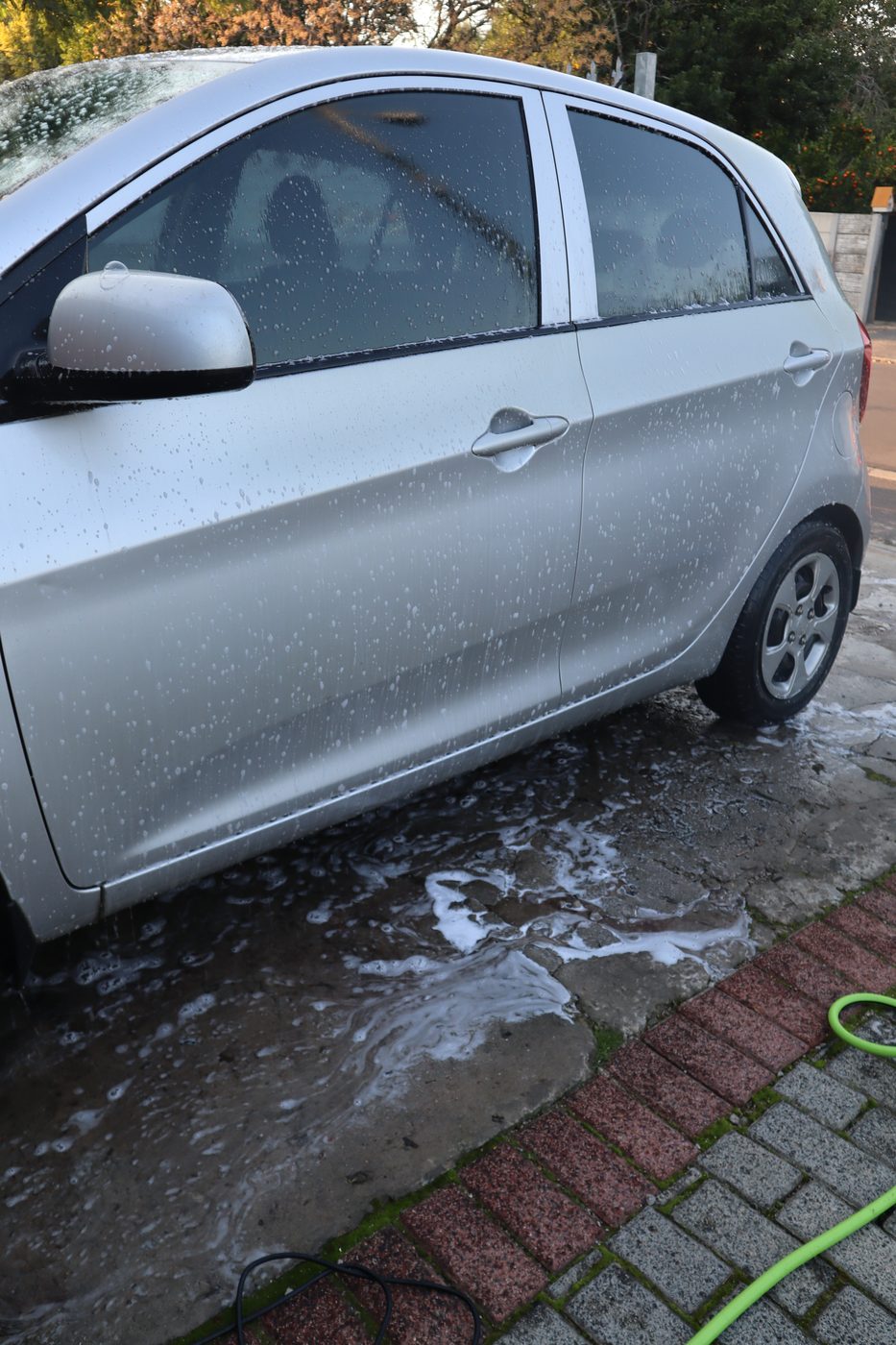 Exterior wash foam treatment on a silver hatchback